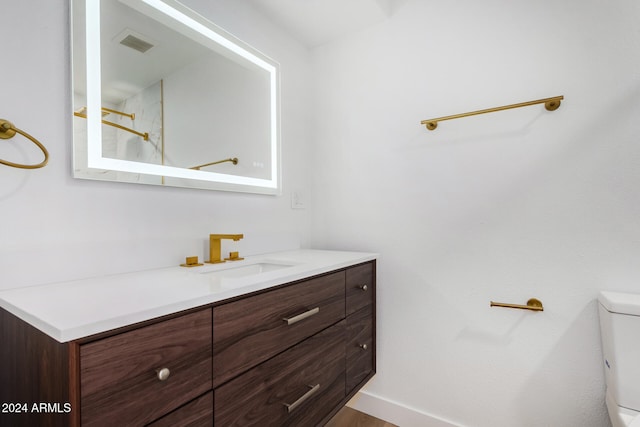 bathroom featuring vanity, hardwood / wood-style floors, and toilet