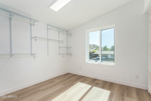 walk in closet featuring lofted ceiling and light hardwood / wood-style floors