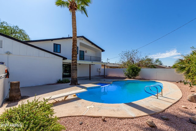 view of pool featuring a diving board and a patio