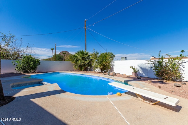 view of swimming pool featuring a patio area and a diving board