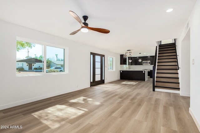 unfurnished living room featuring ceiling fan, a healthy amount of sunlight, and hardwood / wood-style floors