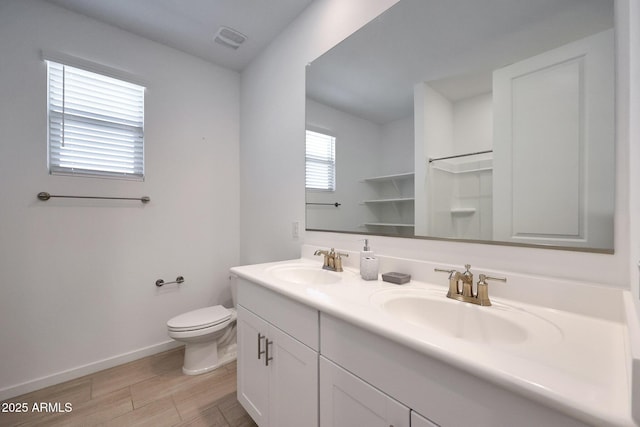 full bathroom featuring visible vents, toilet, baseboards, and a sink