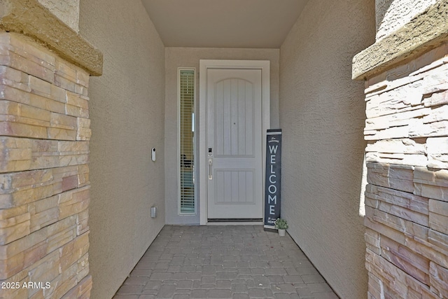 property entrance with stucco siding