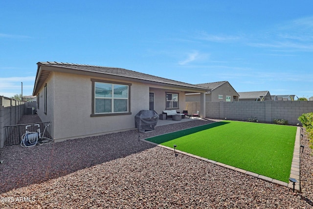 back of house with a patio, a fenced backyard, a lawn, and stucco siding