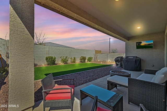 patio terrace at dusk featuring grilling area, outdoor lounge area, and a fenced backyard