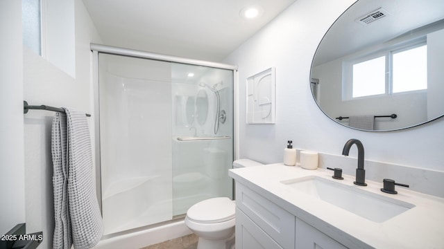 bathroom with vanity, a shower with shower door, and toilet