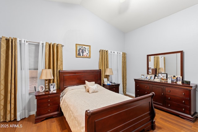 bedroom featuring lofted ceiling and light hardwood / wood-style flooring