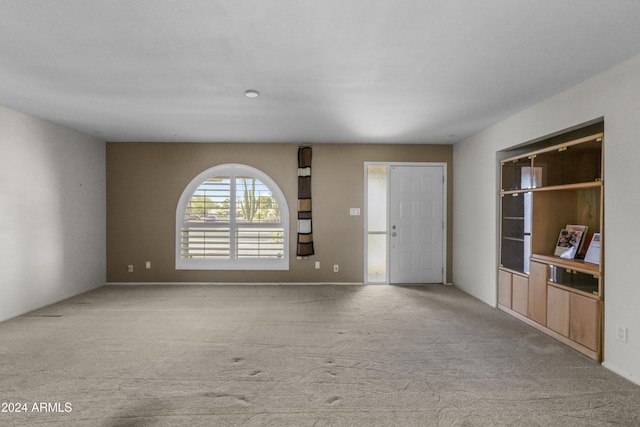 unfurnished living room with light colored carpet