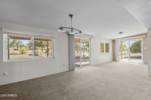 unfurnished living room featuring carpet and a textured ceiling