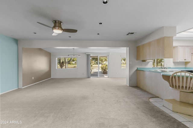 kitchen with ceiling fan, light colored carpet, and light brown cabinetry