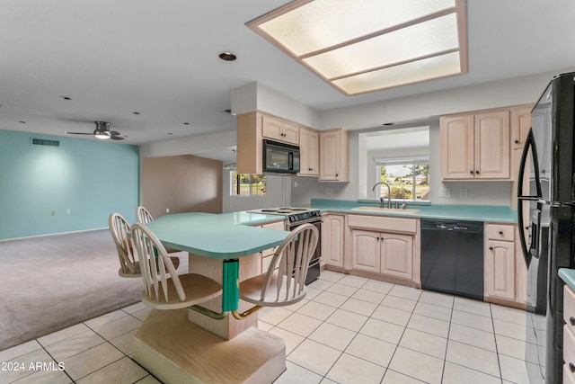 kitchen with light brown cabinets, black appliances, sink, ceiling fan, and light colored carpet