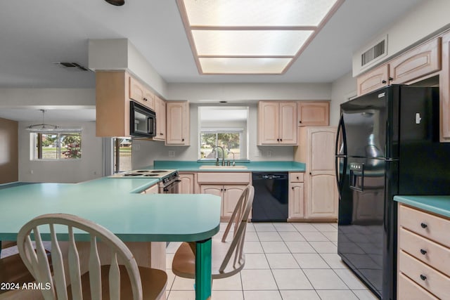 kitchen with black appliances, sink, light tile patterned floors, light brown cabinetry, and kitchen peninsula