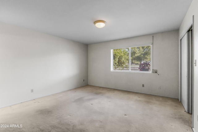 spare room featuring light carpet