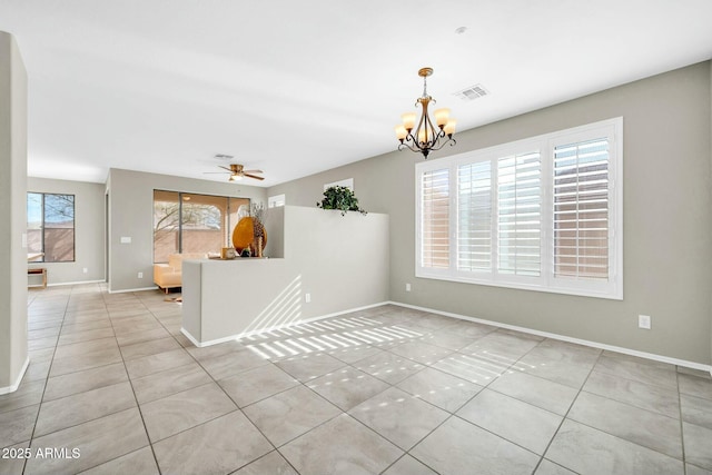 tiled spare room with ceiling fan with notable chandelier