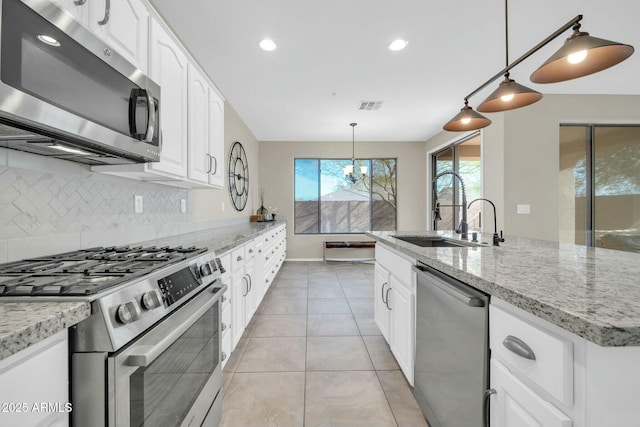 kitchen with pendant lighting, sink, white cabinetry, and appliances with stainless steel finishes