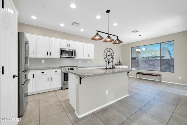 kitchen with stainless steel appliances, decorative light fixtures, a kitchen island with sink, and white cabinets