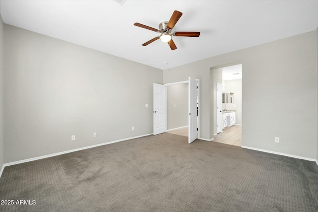 unfurnished bedroom featuring light carpet, connected bathroom, and ceiling fan