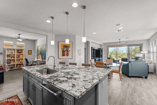 kitchen featuring dishwasher, ceiling fan, a kitchen island with sink, and sink