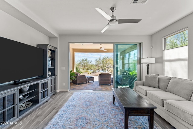 living room featuring ceiling fan and light hardwood / wood-style flooring