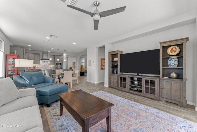 living room with ceiling fan and light hardwood / wood-style floors