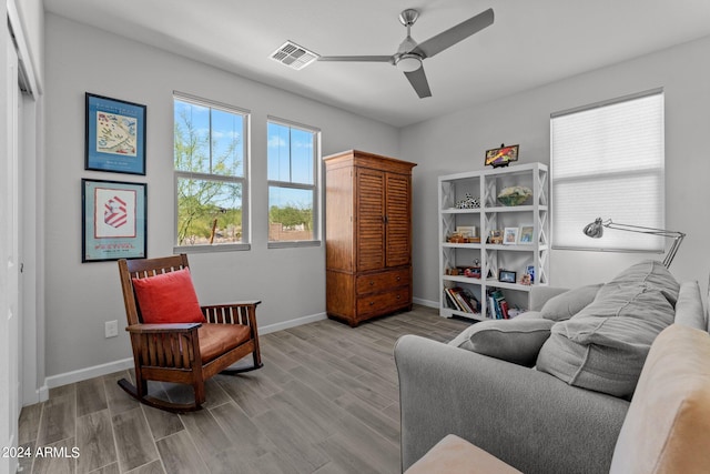 living room featuring light hardwood / wood-style flooring and ceiling fan