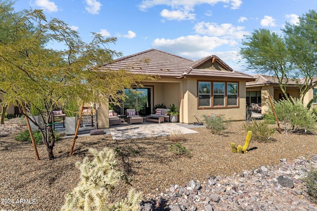 rear view of house with outdoor lounge area and a patio area