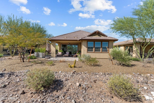 rear view of property with a patio and an outdoor living space