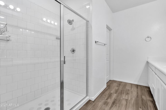 bathroom with hardwood / wood-style flooring, vanity, and an enclosed shower