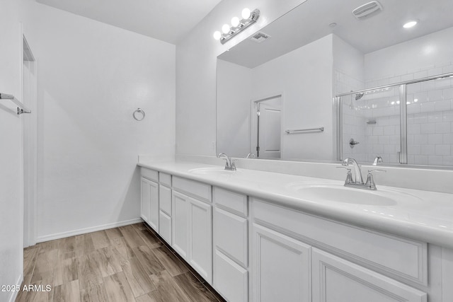 bathroom featuring vanity, hardwood / wood-style floors, and a shower with shower door