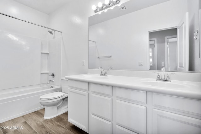 full bathroom featuring shower / bath combination, vanity, hardwood / wood-style floors, and toilet