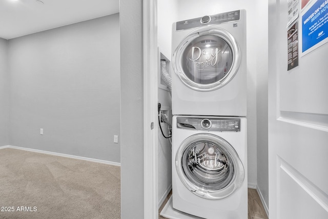 laundry area featuring stacked washer and clothes dryer and carpet flooring