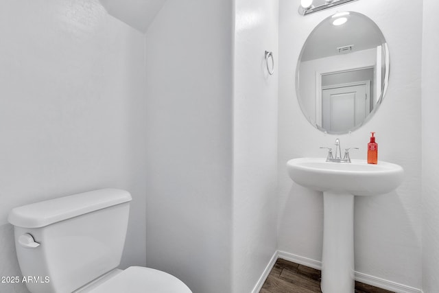 bathroom featuring hardwood / wood-style floors and toilet