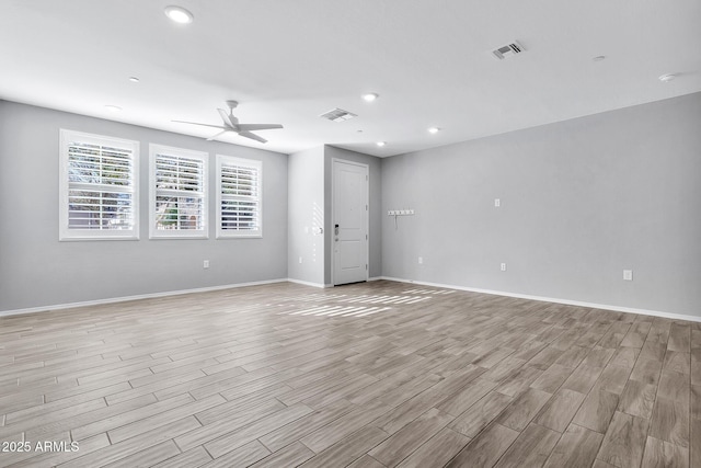 spare room with ceiling fan and light wood-type flooring