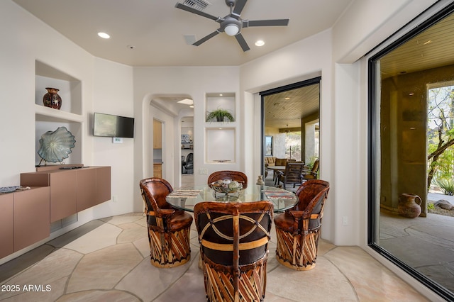 dining room featuring built in shelves and ceiling fan