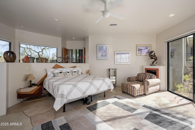 bedroom featuring ceiling fan, access to exterior, and multiple windows