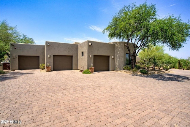 pueblo revival-style home featuring a garage