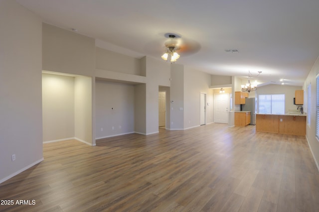 1563 E Peregrine Trl, Casa Grande, AZ 85122 - unfurnished living room featuring a chandelier, lofted ceiling, a ceiling fan, wood finished floors, and baseboards