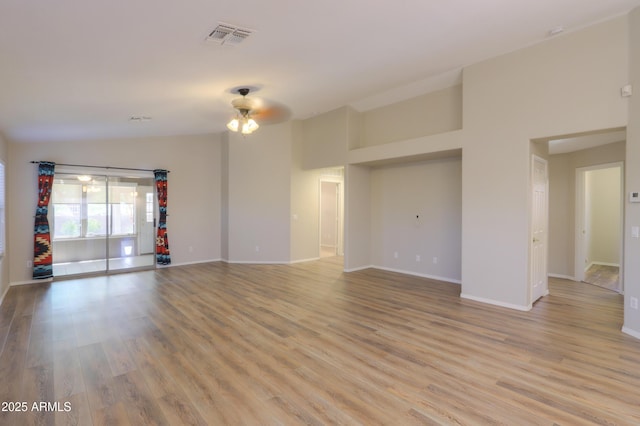 1563 E Peregrine Trl, Casa Grande, AZ 85122 - unfurnished living room featuring a ceiling fan, light wood-type flooring, and baseboards