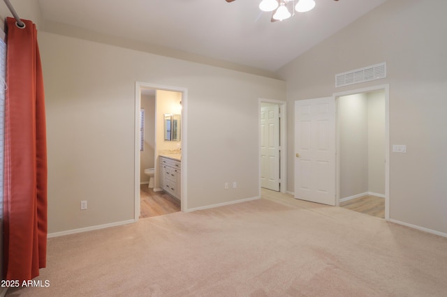 1563 E Peregrine Trl, Casa Grande, AZ 85122 - unfurnished bedroom with light carpet, baseboards, high vaulted ceiling, connected bathroom, and a ceiling fan