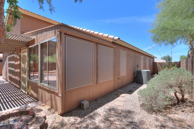 1563 E Peregrine Trl, Casa Grande, AZ 85122 - view of side of home featuring central AC unit, a tile roof, and stucco siding
