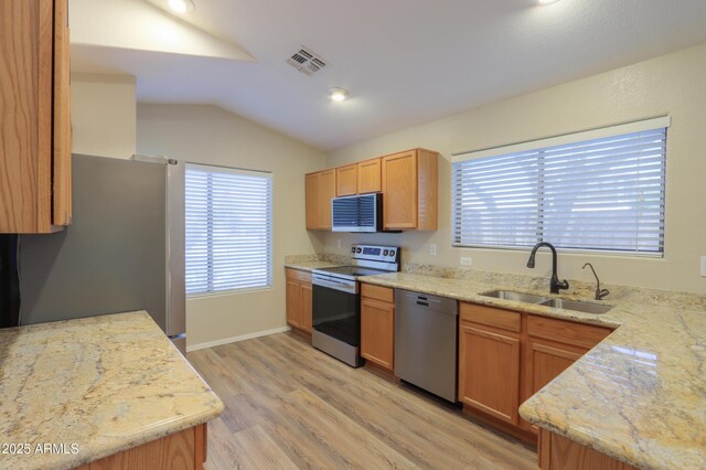 1563 E Peregrine Trl, Casa Grande, AZ 85122 - kitchen with stainless steel appliances, a sink, lofted ceiling, light wood finished floors, and light stone countertops