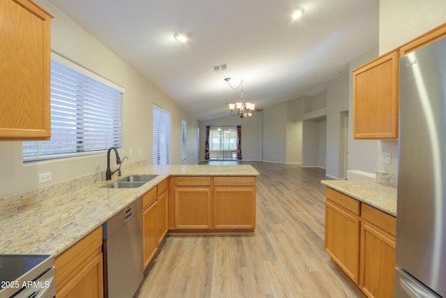 1563 E Peregrine Trl, Casa Grande, AZ 85122 - kitchen with appliances with stainless steel finishes, a sink, light wood-style floors, a chandelier, and a peninsula