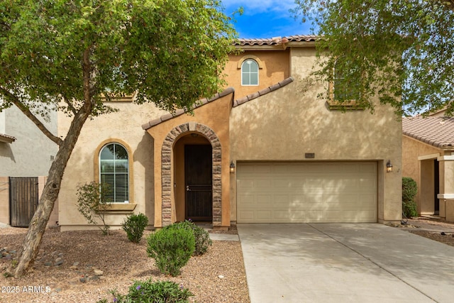 mediterranean / spanish house featuring a tiled roof, driveway, and stucco siding