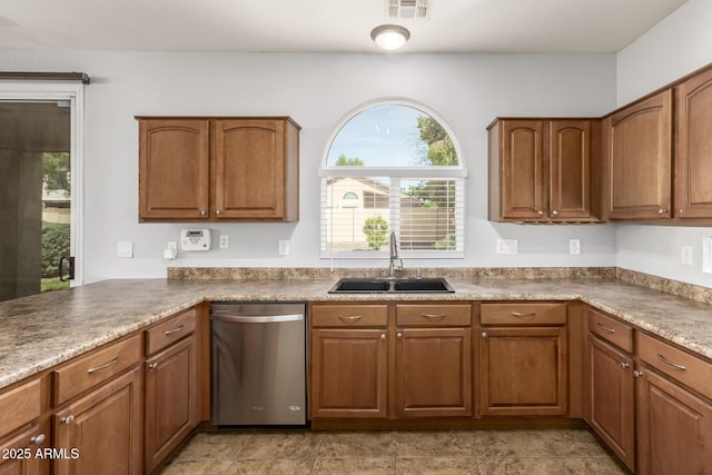 kitchen with dishwasher, a sink, brown cabinetry, and visible vents
