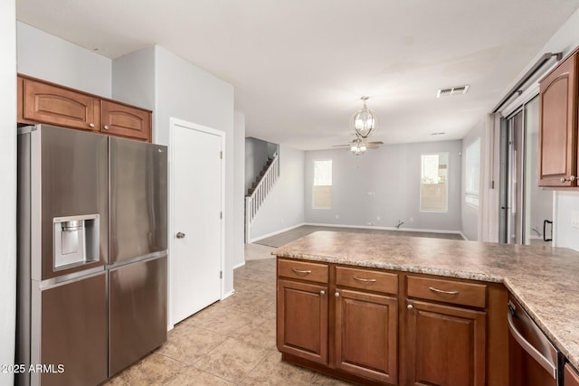 kitchen with a notable chandelier, a peninsula, brown cabinets, stainless steel appliances, and visible vents