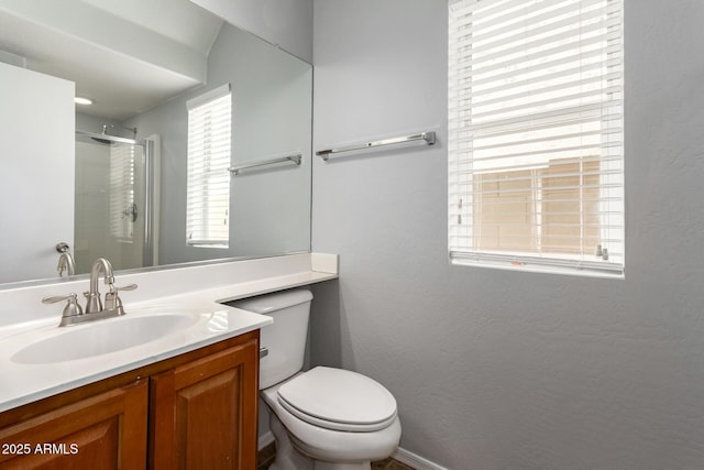 bathroom featuring toilet, a shower with shower door, a textured wall, and vanity