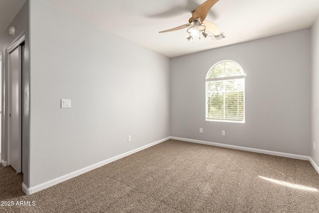 carpeted spare room with a ceiling fan, baseboards, and visible vents