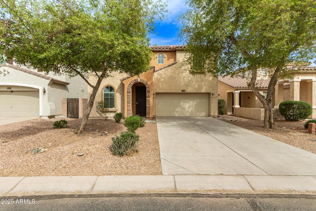 mediterranean / spanish house featuring driveway, stucco siding, a tile roof, and a garage