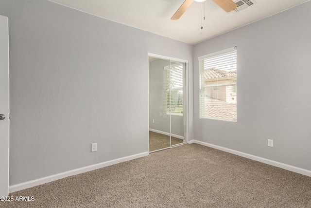 unfurnished bedroom featuring baseboards, visible vents, a closet, and carpet flooring