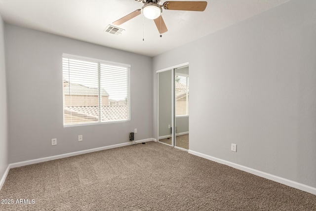 unfurnished bedroom featuring baseboards, visible vents, ceiling fan, and carpet floors